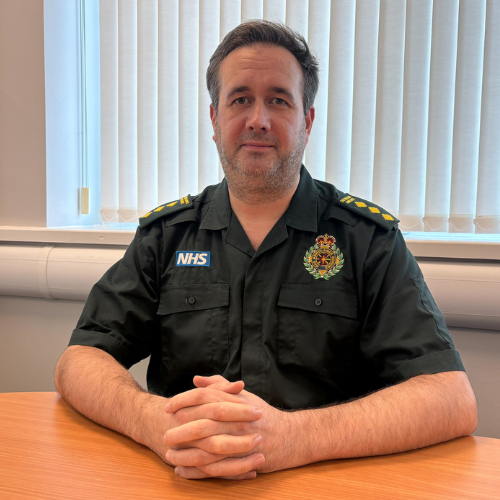Michael Hanley sat at a desk wearing his EMAS uniform.