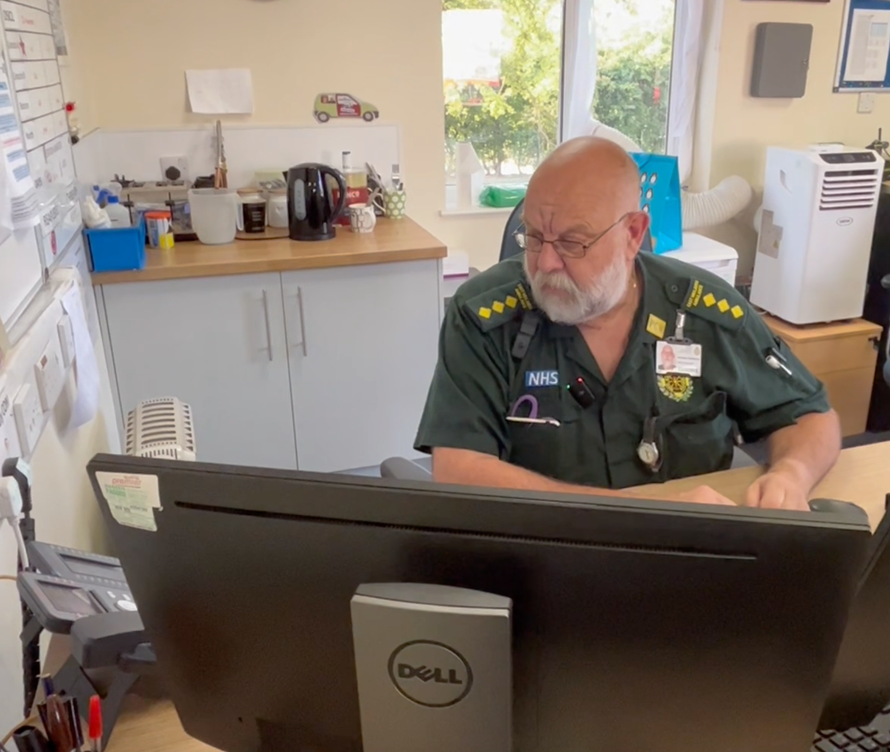 Paf sat at his desk on a call to a colleague after trying to make contact with a crew to check they're ok while on a response to a patient.
