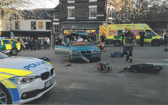 car in the town centre after the collision surrounded by emergency respond units