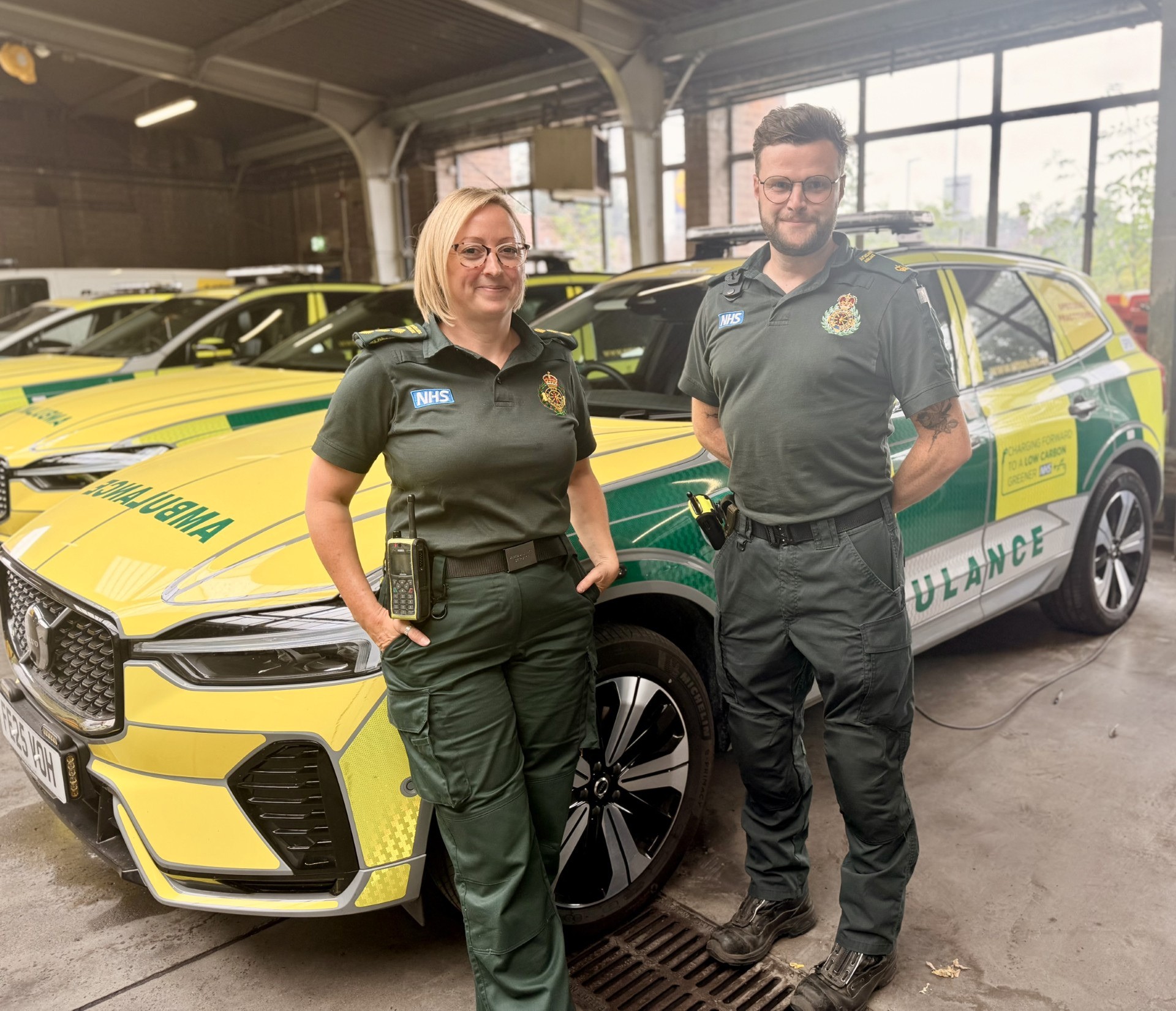Nicola Stewart and Jamie Hahn standing together in ambulance uniform in front of a solo response car.