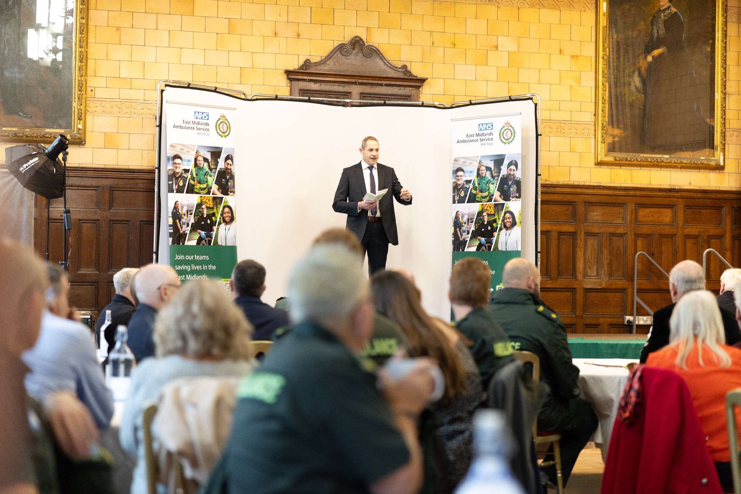 Will Legge is stood on the stage at the awards event talking to the audience.