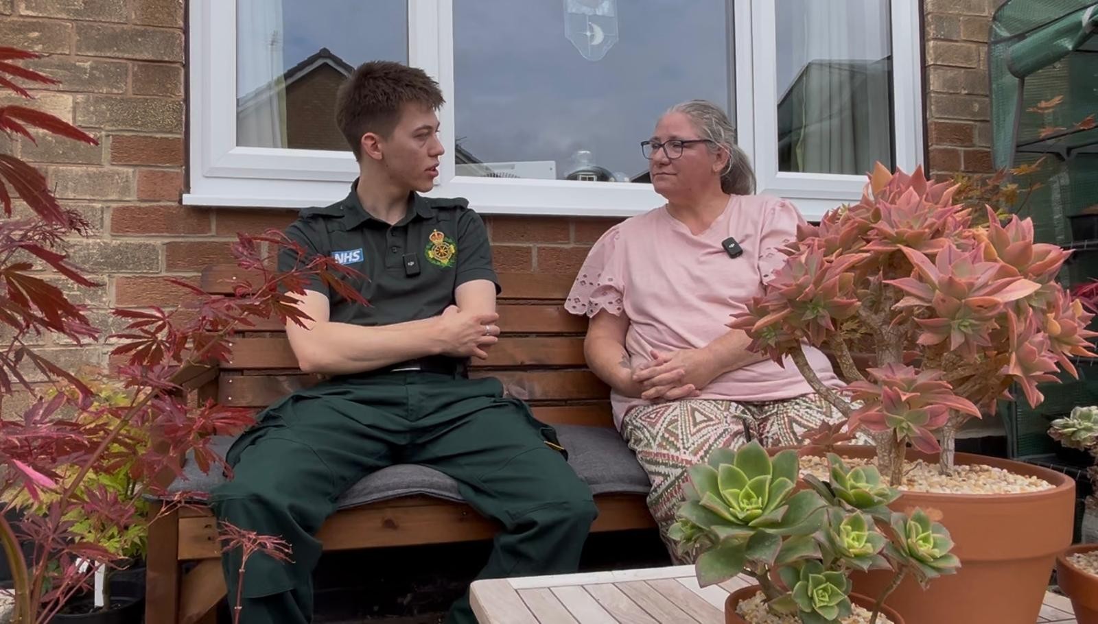 Will Cook and Julie Brooking sat in a garden looking at each other as they're having a conversation
