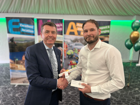 George Bugg shakes hands with Divisional Director Greg Cox as he receives his recognition reward