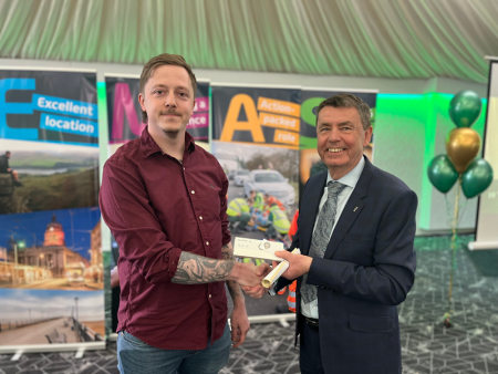 Alex Heath shakes hands with Divisional Director Greg Cox as he receives his recognition reward.