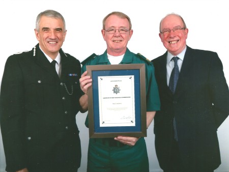 Nick smiles as he holds up his Chief Executive Commendation.