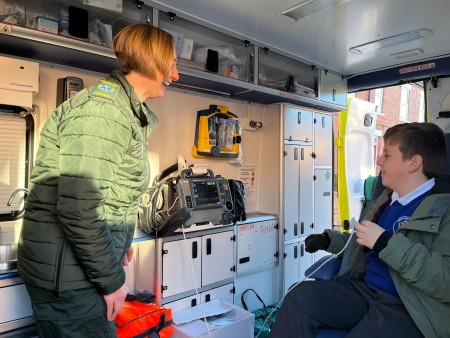 Tracey Smith and Harrison Teague in the back of an ambulance. Tracey connects Harrison to a heart monitor so he can see his heart rate.