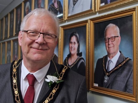 Mayor posing in front of his photo on the wall.jpeg