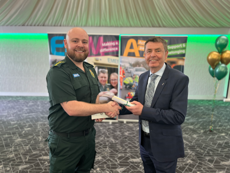 Ben Bates shakes hands with Divisional Director Greg Cox while he receives his recognition reward.