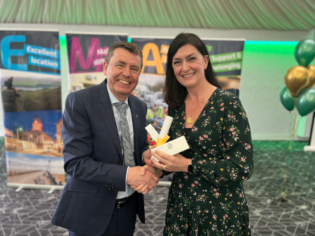 Emma Pearce shakes hands with Divisional Director Greg Cox as she receives her recognition reward.