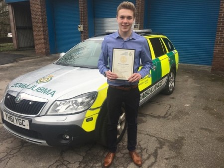 Guy posing in front of ambulance with certificate.jpeg